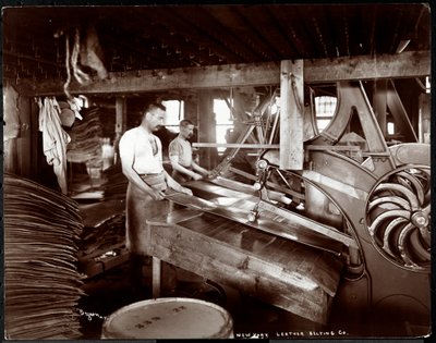 Innenansicht von zwei Männern, die mit Leder und schweren Geräten in der New York Leather Belting Co., New York, 1905 arbeiten von Byron Company